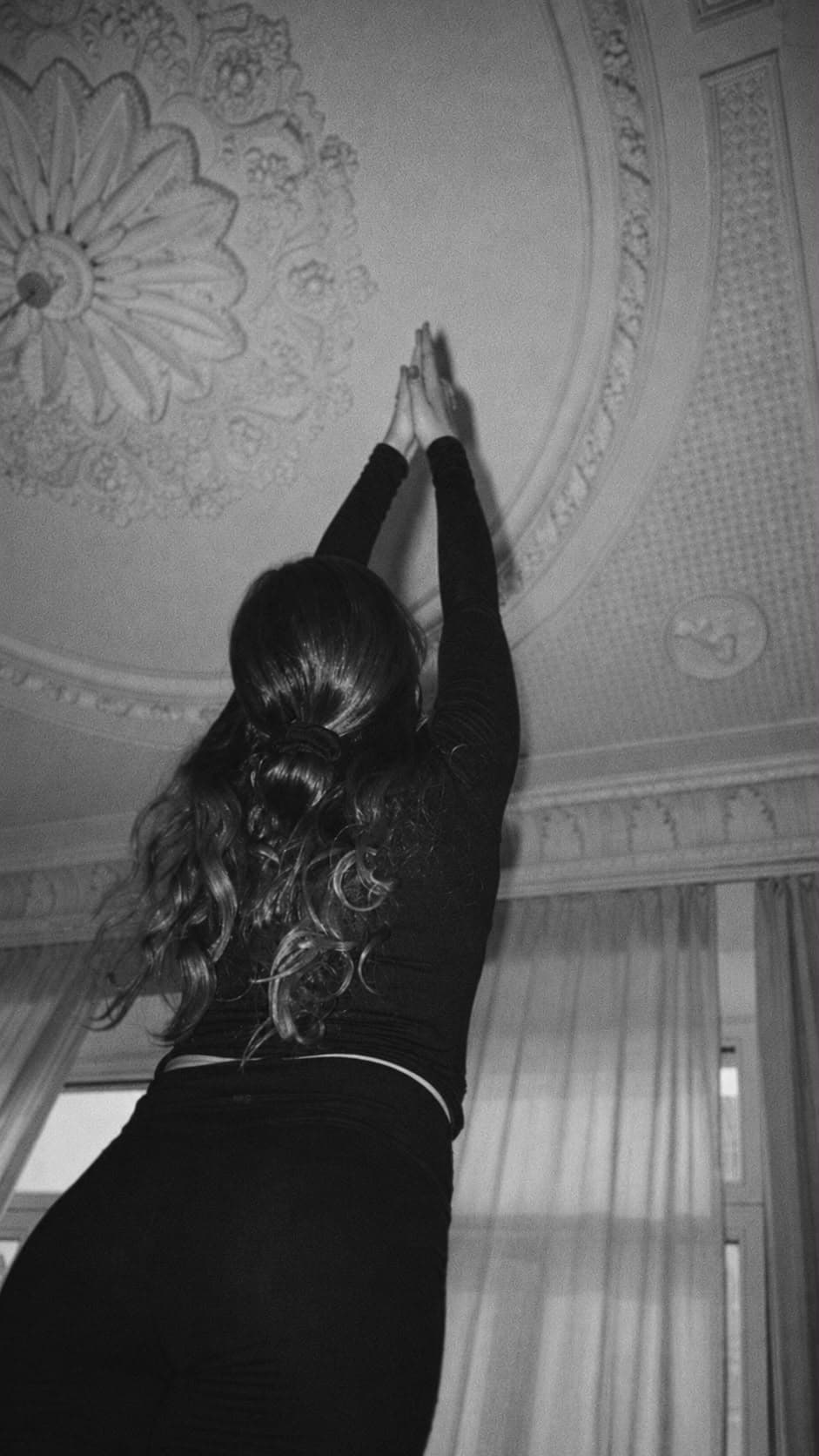 Yoga-Pose mit erhobenen Armen unter ornamentierter Decke